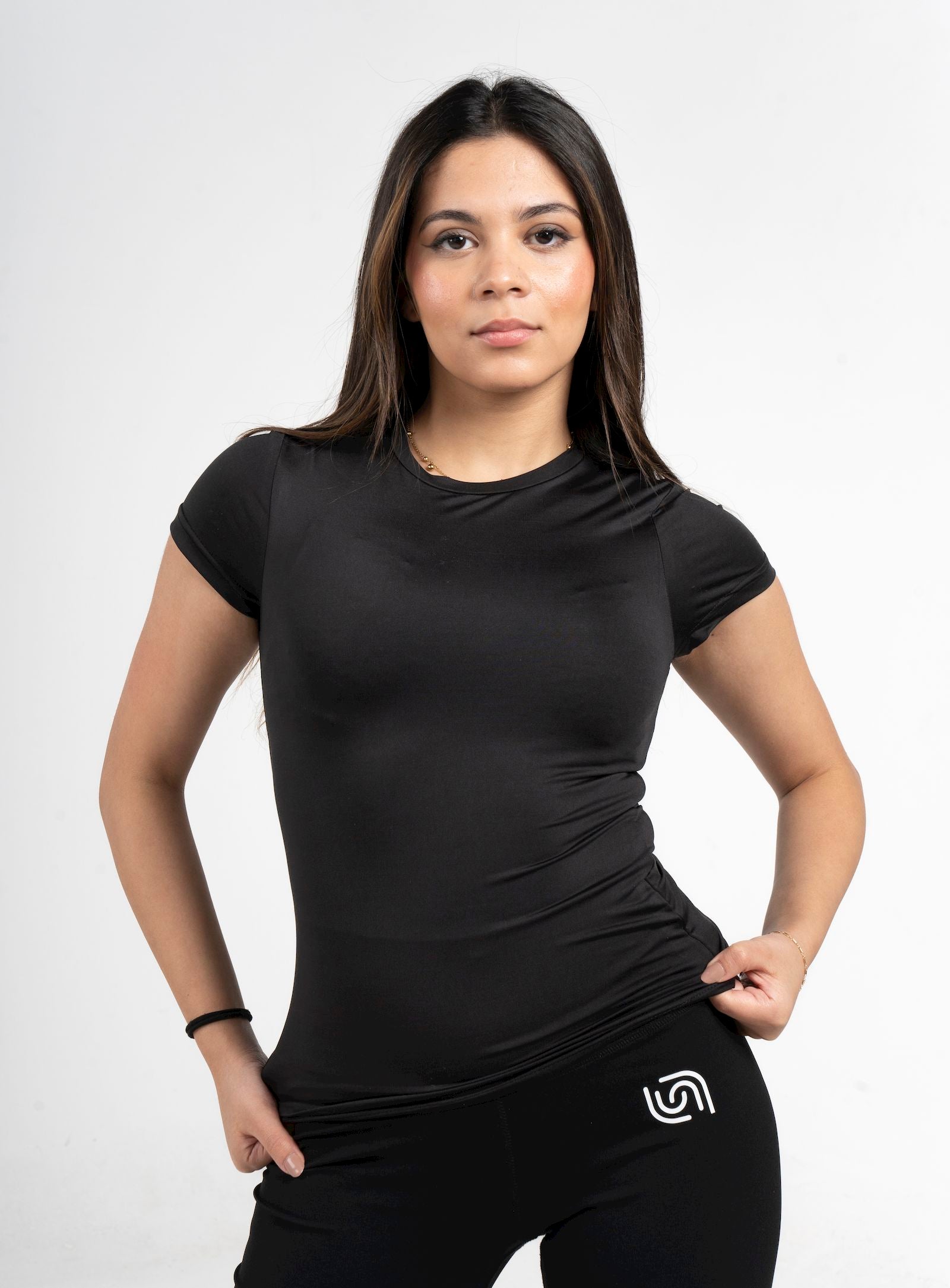 Woman wearing a black athletic outfit with a logo on a white background